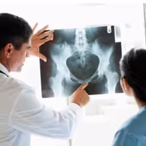 Doktor, hastaya röntgen görüntüsü gösteriyor, evde bakım ve sağlık hizmetleri sunuyor.